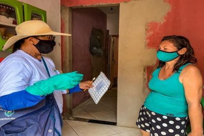 À esquerda uma agente de endemias conversa com uma moradora sobre o combate a dengue.