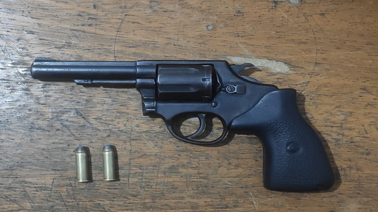 Imagem de revolver preto com duas munições não utilizadas